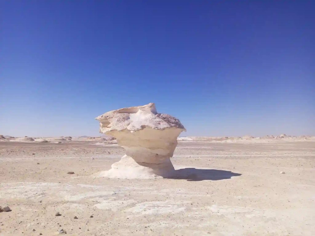 Mushroom shaped limestone rock formation in the White Desert Western Desert Egypt under clear blue sky