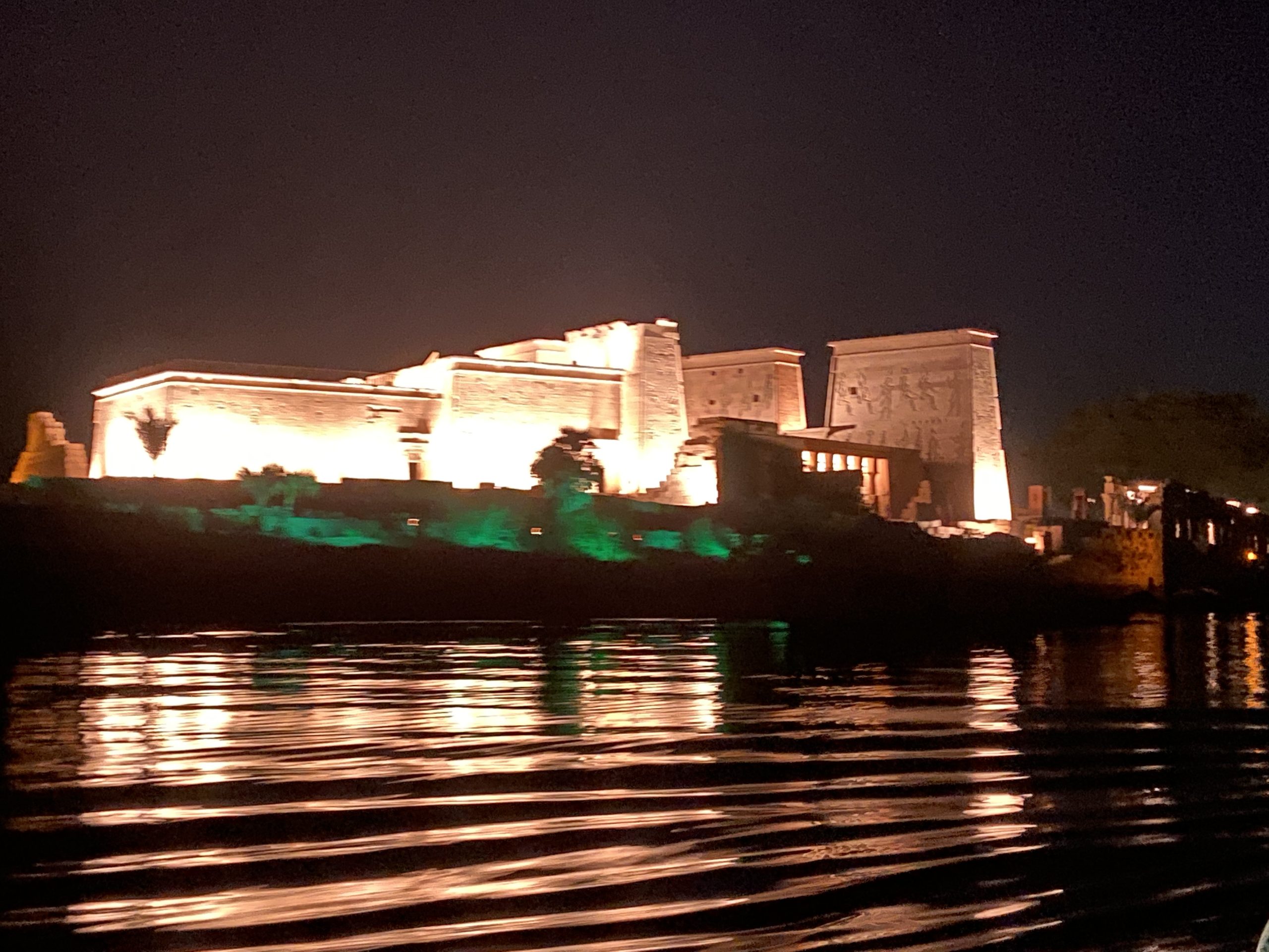 Illuminated Temple of Philae at night reflected in the Nile River near Aswan, Egypt