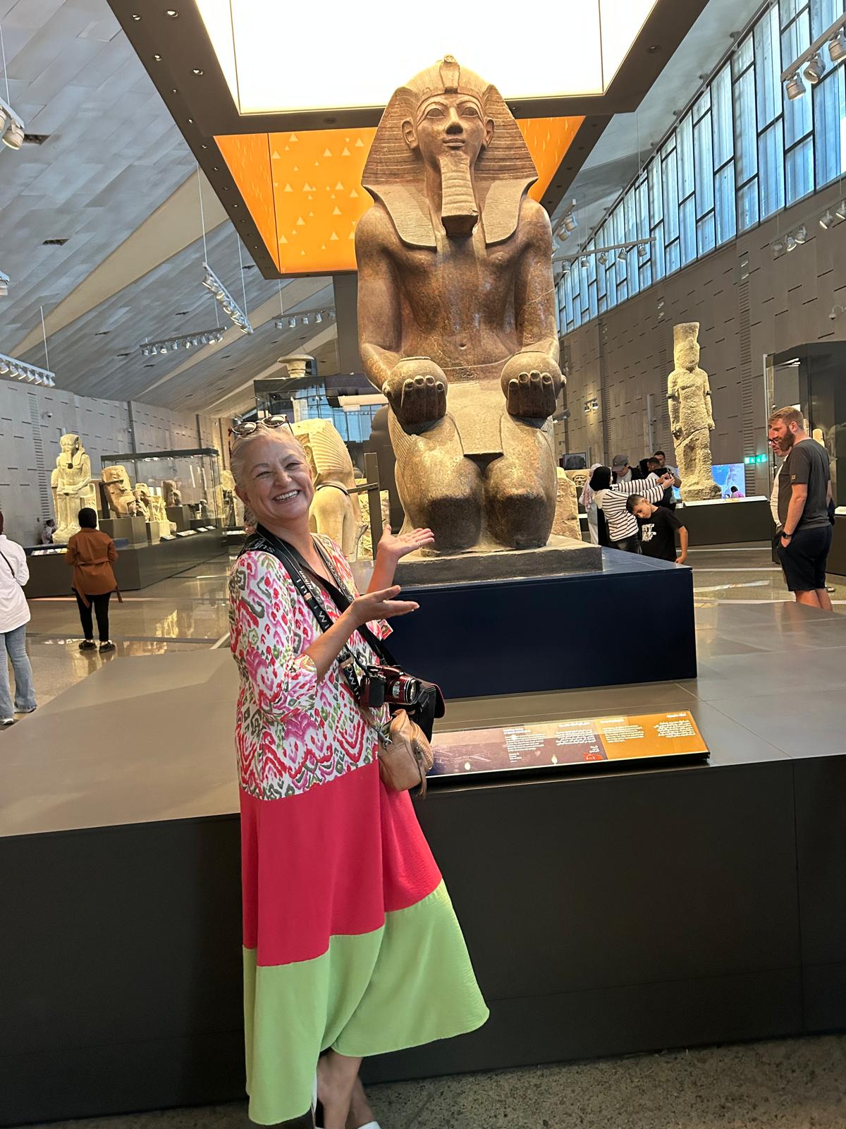 Catalina Garay standing beside the colossal statue of Ramses II inside the Grand Egyptian Museum in Giza, Egypt